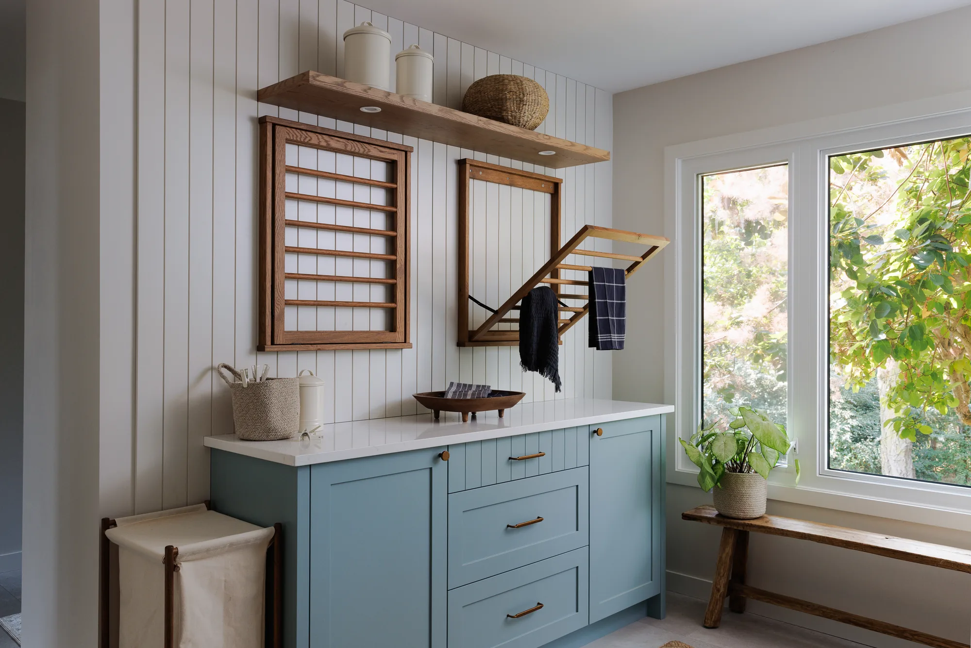 Laundry room with blue Shaker cabinetry, vertical panelling and fold-down oak drying racks, 10 Mile Point renovation by Maverick Design, Victoria BC