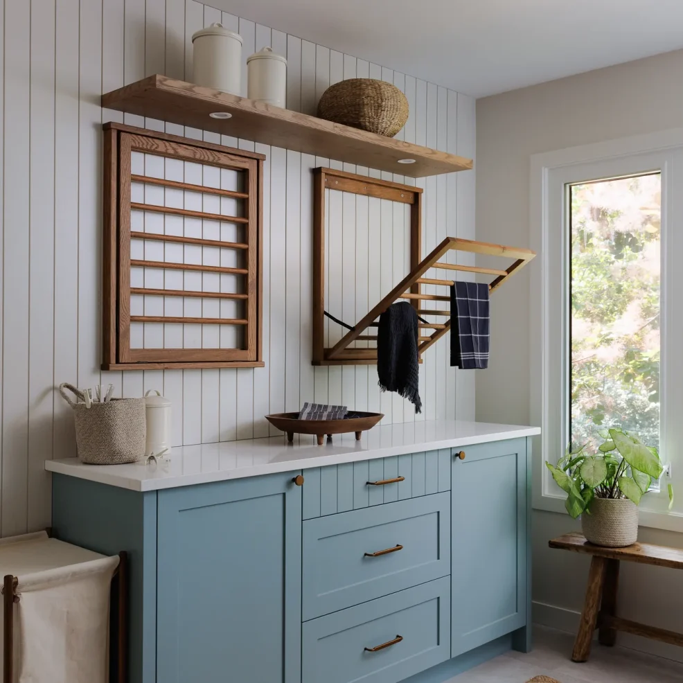Laundry room with blue Shaker cabinetry, vertical panelling and fold-down oak drying racks, 10 Mile Point renovation by Maverick Design, Victoria BC