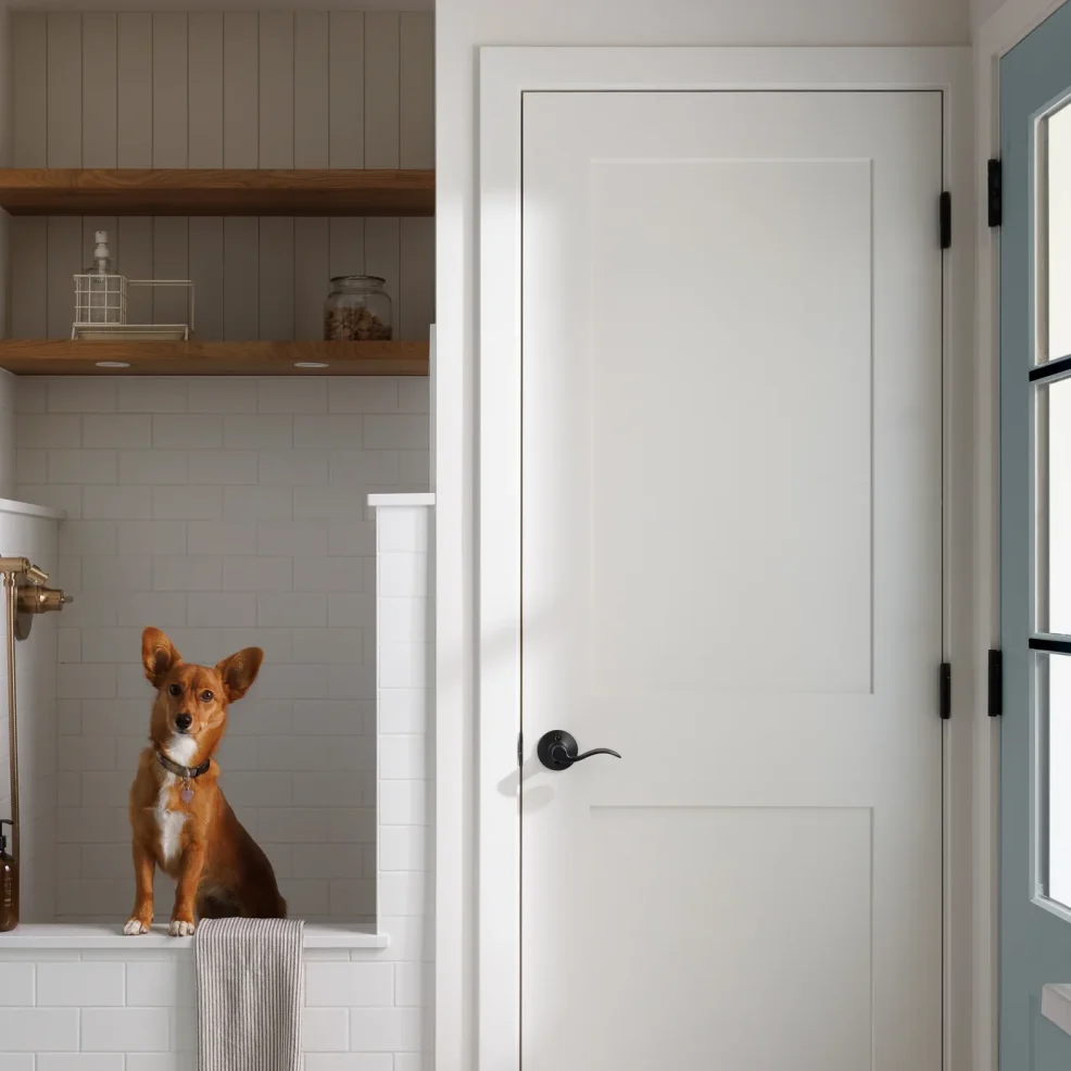 Mudroom dog wash station with white subway tile, brass hand shower and oak floating shelves, 10 Mile Point renovation by Maverick Design, Victoria BC