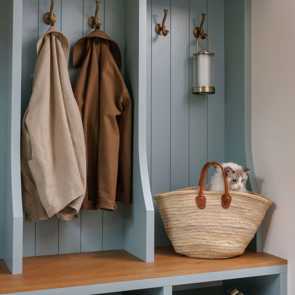 Mudroom lockers in blue with vertical panelling, brass hooks, oak bench and shoe cubbies, 10 Mile Point renovation by Maverick Design, Victoria BC