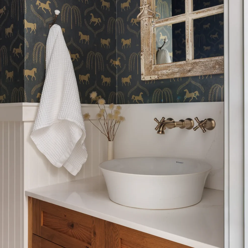 Powder room with equestrian wallpaper, wood vanity, vessel sink and wall-mounted brass faucet, 10 Mile Point renovation by Maverick Design, Victoria BC